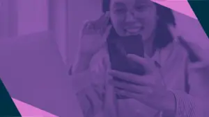 Purple duotone image of woman in glasses holding a phone and looking at the screen