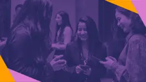 Three women at an event smiling at a phone