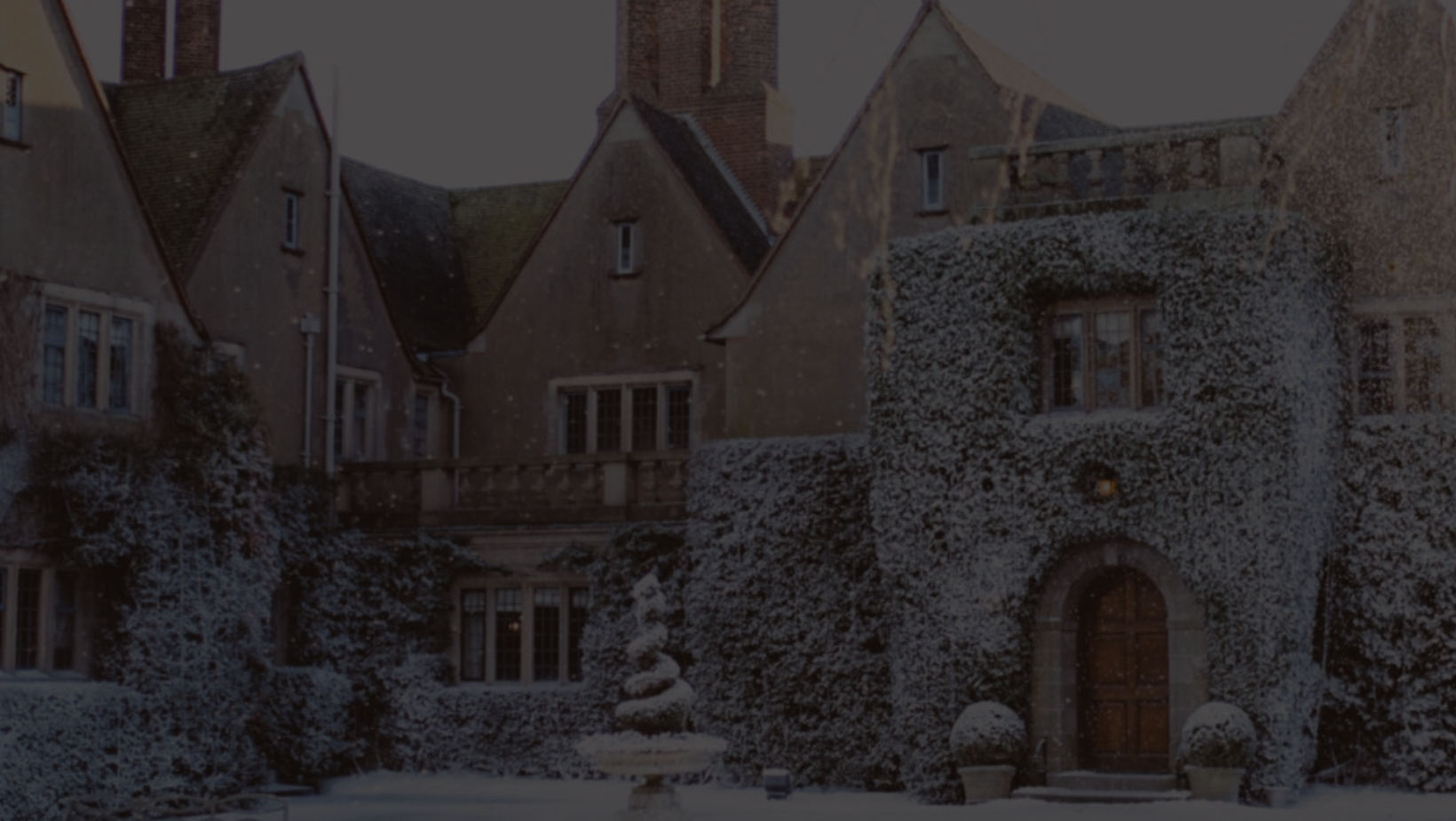 A view of the exterior of Mallory Court Country House Hotel & Spa, an old snow-covered estate