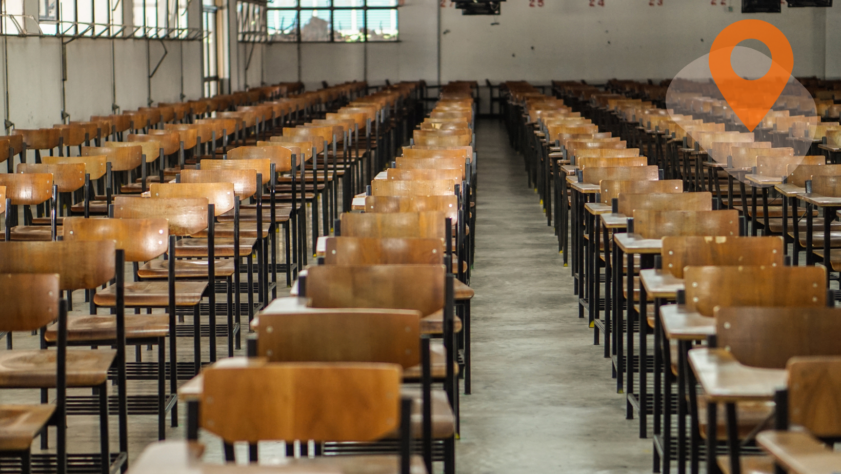 Empty exam hall with rows of tables and chairs