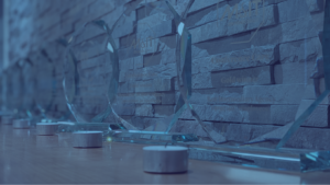 Blue Duotone image of M&IT awards lined on a desk